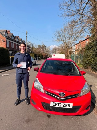 Student celebrating a driving test pass with learner car
