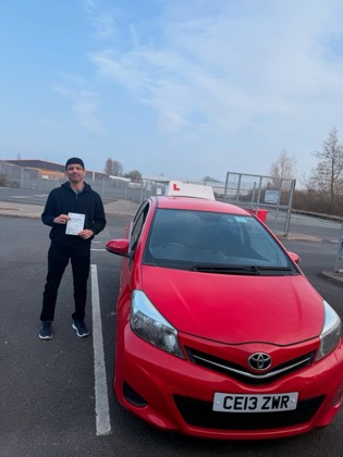 Student celebrating a driving test pass with learner car