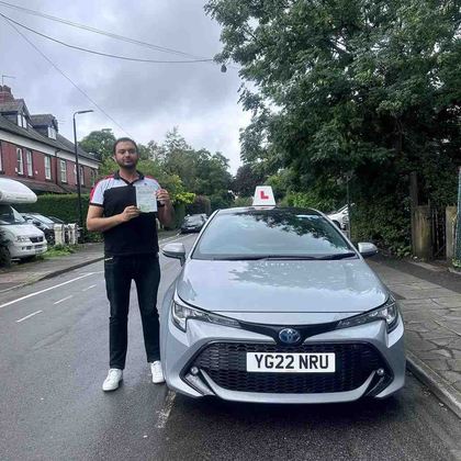 NextPass learner celebrating a driving test pass beside a Toyota learner car